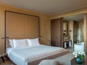 um quarto com uma cama grande e uma casa de banho em ME Milan Il Duca em Milão