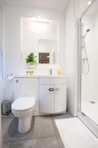 a white bathroom with a toilet and a mirror at Urban Living's - The King Edward I Luxury Apartment in the Heart of Windsor in Windsor