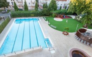 an overhead view of a large swimming pool with a green yard at Hotel Barátság in Hajdúszoboszló