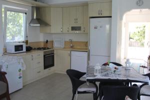 a kitchen with a table and a white refrigerator at VillaSevval - Stunning 4-Bed Villa in Dalyan