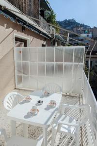 a white table and chairs on a balcony at Cozy apt with Lycabettus View! in Athens