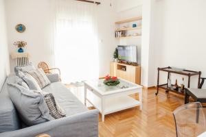 a living room with a couch and a table at Cozy apt with Lycabettus View! in Athens