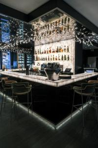 um bar num restaurante com bancos de bar em Hotel-Restaurant Valrose em Gstaad