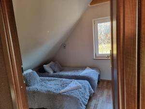 a attic room with two beds and a window at vinico in Piechowice