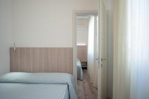 1 dormitorio con 1 cama y puerta a una habitación en Hotel San Francisco, en Lido di Savio