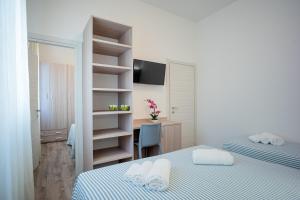 a bedroom with two beds and a desk with a computer at Hotel San Francisco in Lido di Savio