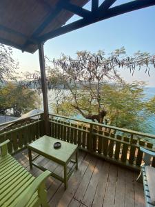 a table and chairs on a deck with a view of the ocean at Mayoka Village Beach Lodge in Nkhata Bay