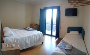 1 Schlafzimmer mit 2 Betten und einer Tür zu einem Balkon in der Unterkunft Casa Da Ameixieira in Arouca