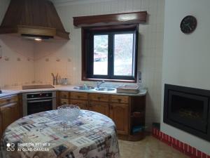 een keuken met een tafel, een wastafel en een raam bij Casa Da Ameixieira in Arouca