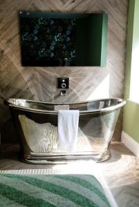 een badkamer met een bad en een groene muur bij Draycote Hotel And Whitefields Golf Course in Rugby