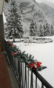 a fence with christmas decorations on it in the snow at Baggio House in Cadarese