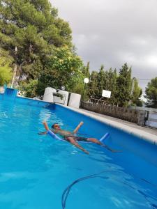 a man is swimming in a swimming pool at Habitacion en casa rural particular el Palomar in Villena