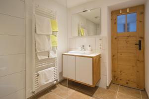 a white bathroom with a sink and a mirror at Ferienwohnung Lacherhof in Seehausen am Staffelsee