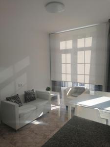 sala de estar con sofá blanco y mesa en Vivienda de uso turístico Alma da Costa da Morte, en Sardiñeiro de Abajo
