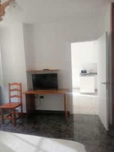 a desk with a television and a chair in a room at Vivienda de uso turístico Alma da Costa da Morte in Sardiñeiro de Abajo