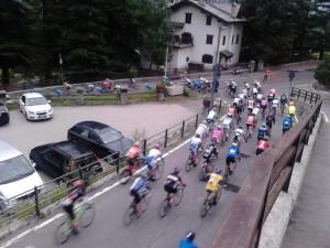 a group of people riding bikes down a street at Hotel Ottoz Meublé in Courmayeur