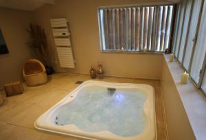 a large bath tub in a bathroom with a window at La Haute Flourie - bed and breakfast -chambres d'hôtes in Saint Malo