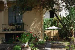 a house with a patio with a table and an umbrella at Il Melangolo in SantʼAntìoco