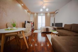 - un salon avec un canapé et une table dans l'établissement Apartman In Lux, à Vrnjačka Banja