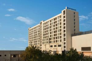 un gran edificio blanco con un cartel. en Wyndham Ahmedabad Shela en Ahmedabad