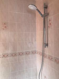 a shower with a shower head in a bathroom at Bob's House quiet retreat in 3 bed house with gym in Loughborough