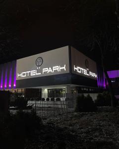 a hotel park with a lit up sign at night at Hotel Park in Opoczno