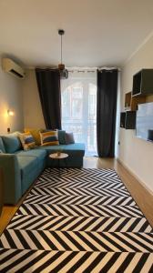 a living room with a blue couch and a rug at Burgas apartment in Burgas City