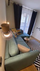 a living room with a green couch with a lamp at Burgas apartment in Burgas City