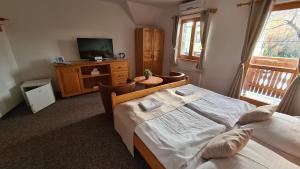 a bedroom with two beds and a tv on a dresser at Hotel Koliba in Senec +55 photos