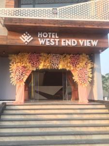 a hotel entrance with vases of flowers on the stairs at Hotel West End View in Zirakpur