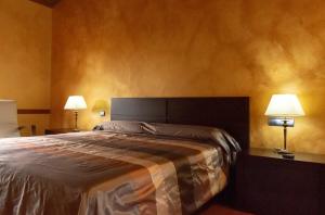 a bedroom with a large bed with two lamps at Casa rural Legus Belikiom in Belchite