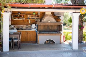 an outdoor kitchen with a pizza oven in a patio at Zervos Apartments Bouka in Lefkimmi
