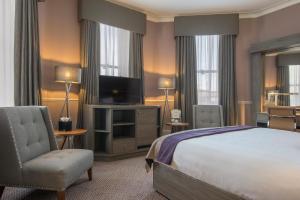 - une chambre avec un lit, une télévision et une chaise dans l'établissement Crowne Plaza - Sheffield, an IHG Hotel, à Sheffield