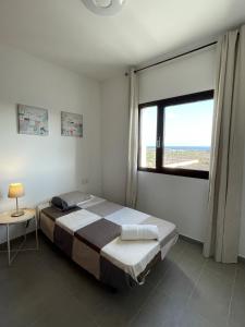 um quarto com uma cama e uma grande janela em Mirador del Mar Lanzarote em Costa Teguise