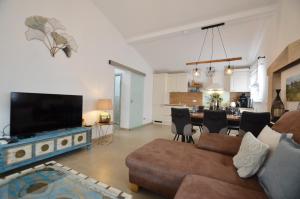 a living room with a couch and a tv and a kitchen at Bella di Campo in Rovinj