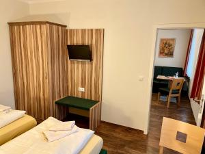 a hotel room with two beds and a table and a desk at Lindenhaus Scharfe Kurve in Rosenow