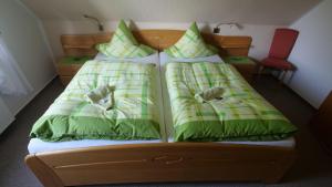 a bedroom with two beds with green and white pillows at Ferienwohnung-Amanda-2 in Bad Zwischenahn