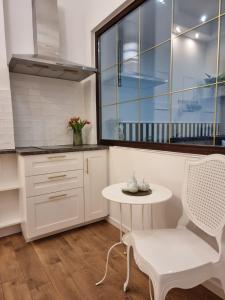 una cucina con tavolo, sedia e finestra di Apartament Skandia Blue a Toruń