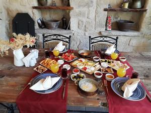 uma mesa de madeira com comida e bebidas em Cappadocia Old Houses em Nevşehir