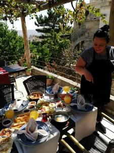 una mujer parada frente a una mesa de comida en Cappadocia Old Houses en Nevşehir