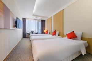 Shin Shin Hotel Jeju Worldcup tesisinde bir odada yatak veya yataklar