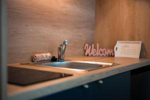 a kitchen counter with a sink and a sign at Resort na jasi in Zreče +19 photos