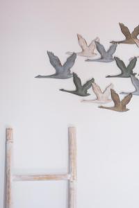 Eine Gruppe Vögel fliegt über eine Mauer in der Unterkunft Cape Suites in Kythnos + 148 Fotos