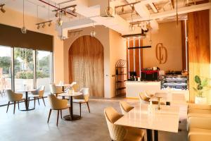 a restaurant with tables and chairs and a kitchen at STAY BY LATINEM Luxury 1BR Holiday Home G6524 near Burj Khalifa in Dubai
