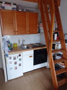 a kitchen with a white refrigerator and a ladder at Les fermettes de la mer 2 in Saint-Jean-de-Monts