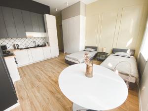 a room with two beds and a white table at Rent-Apart City Center Piotrkowska in Łódź +17 photos