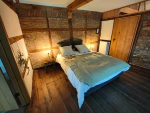 um quarto com uma cama num quarto com pisos em madeira em Le Clos des Brumes em Stoumont