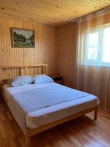 ゴルビツカヤにあるГостевой дом «Ласковый берег»の木製の部屋にベッド1台が備わるベッドルーム1室があります。