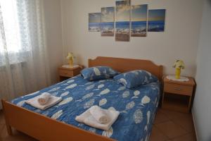 a bedroom with a bed with two pillows on it at Anita's Terrace Apartment in Zambratija