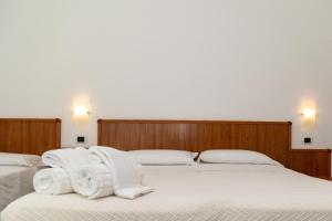 two beds in a room with white towels on them at Hotel Royal in Giulianova